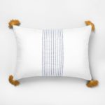 white throw pillow with yellow tassels