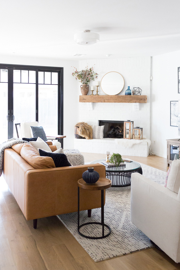 Tan leather modern farmhouse couch in bright airy living room - Design curated by Rare and Worthy Co
